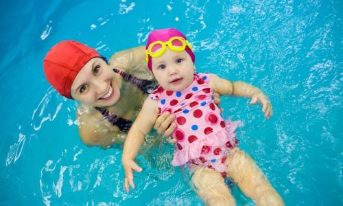 One year  baby girl at his first swimming lesson with mother